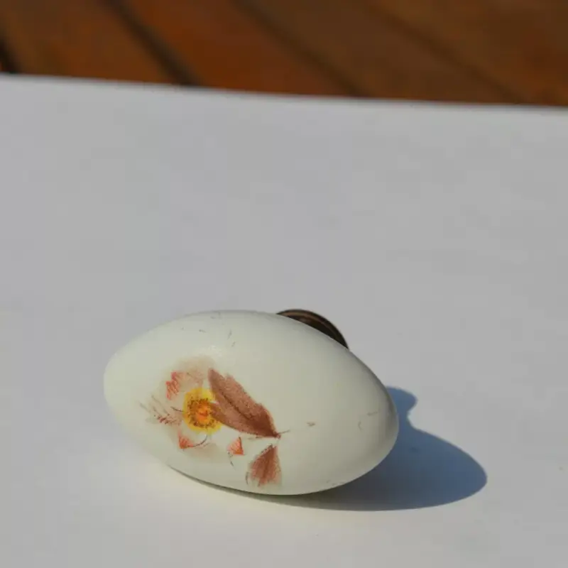 Ovális, porcelán bútorgomb, antik bronz - törtfehér színű, barna virág mintával Ajánlat