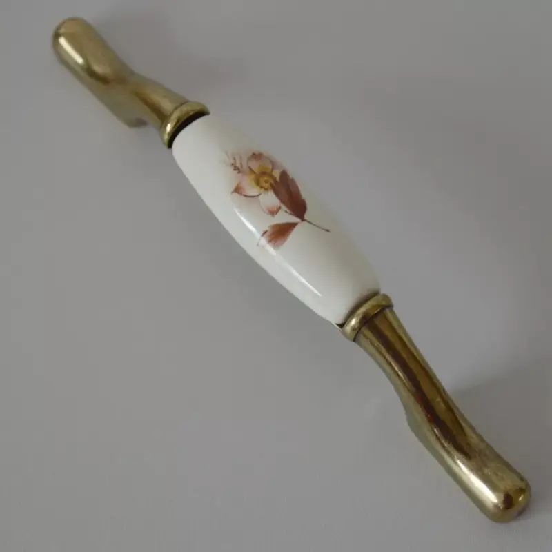Vedd meg most Porzellan-Möbelgriff mit bronzenen Metallenden - cremefarbener Porzellanteil, braunes Blumenmotiv, Bohrung 96 - 128 mm